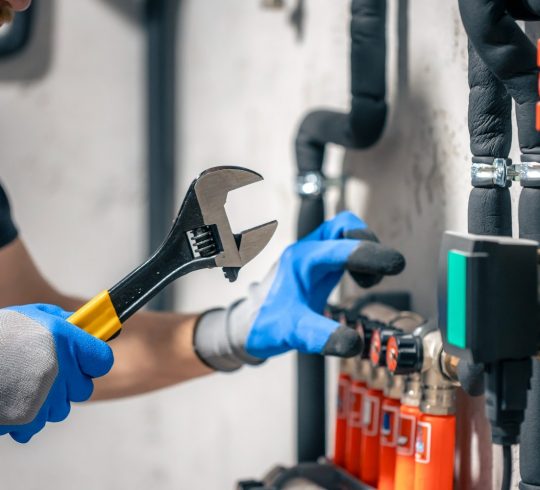 man-installs-heating-system-house-checks-pipes-with-wrench (2)